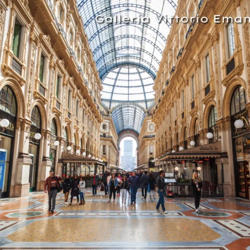 Interior view of the historic Galleria Vittorio Emanuele II shopping arcade featuring a massive glass-vaulted ceiling.