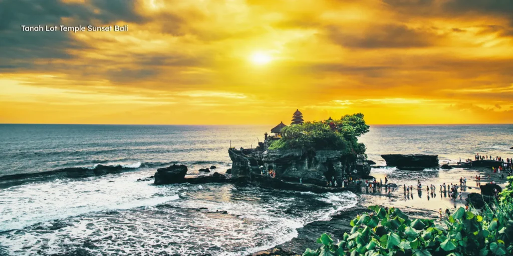 Silhouette of the sacred Tanah Lot Temple built on a rock formation in the ocean during a golden sunset.