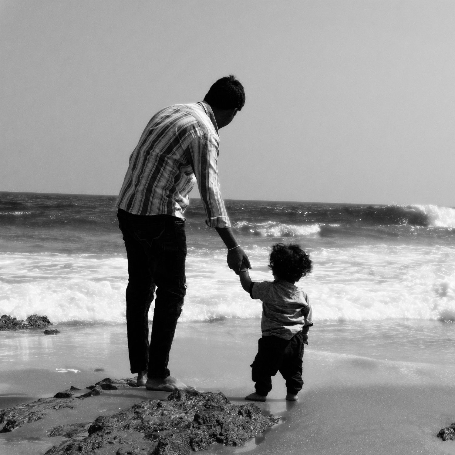 Father and child planning a family holiday with travel photographs, illustrating childhood travel memories from Chennai
