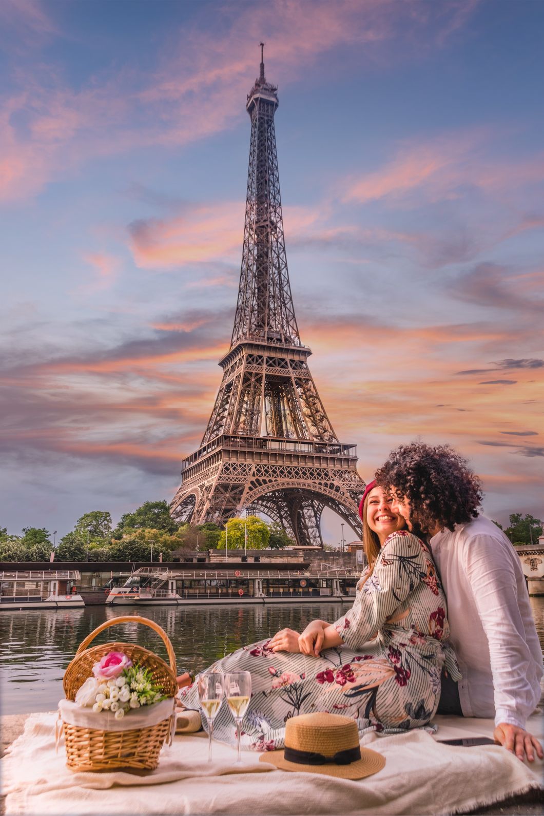 Couple sitting together beneath the Eiffel Tower during a romantic Paris holiday