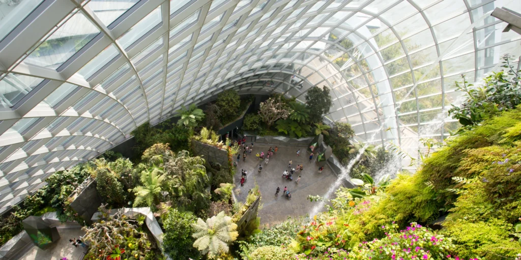 The massive indoor waterfall surrounded by lush tropical plants inside the climate-controlled Cloud Forest at Gardens by the Bay.