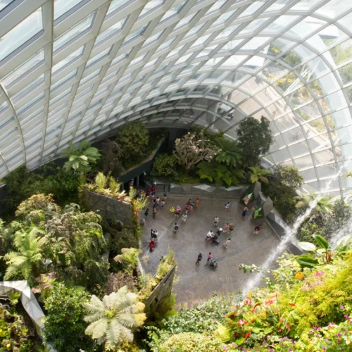 The massive indoor waterfall surrounded by lush tropical plants inside the climate-controlled Cloud Forest at Gardens by the Bay.
