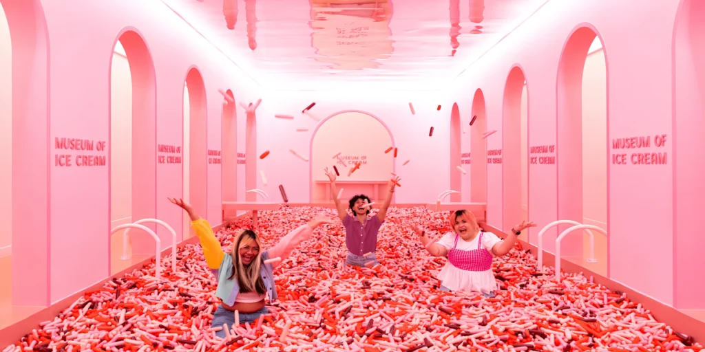 A family playing in the famous pink sprinkle pool inside the Museum of Ice Cream.