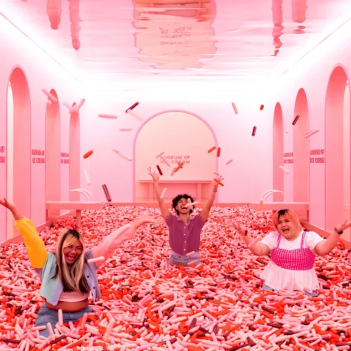 A family playing in the famous pink sprinkle pool inside the Museum of Ice Cream.