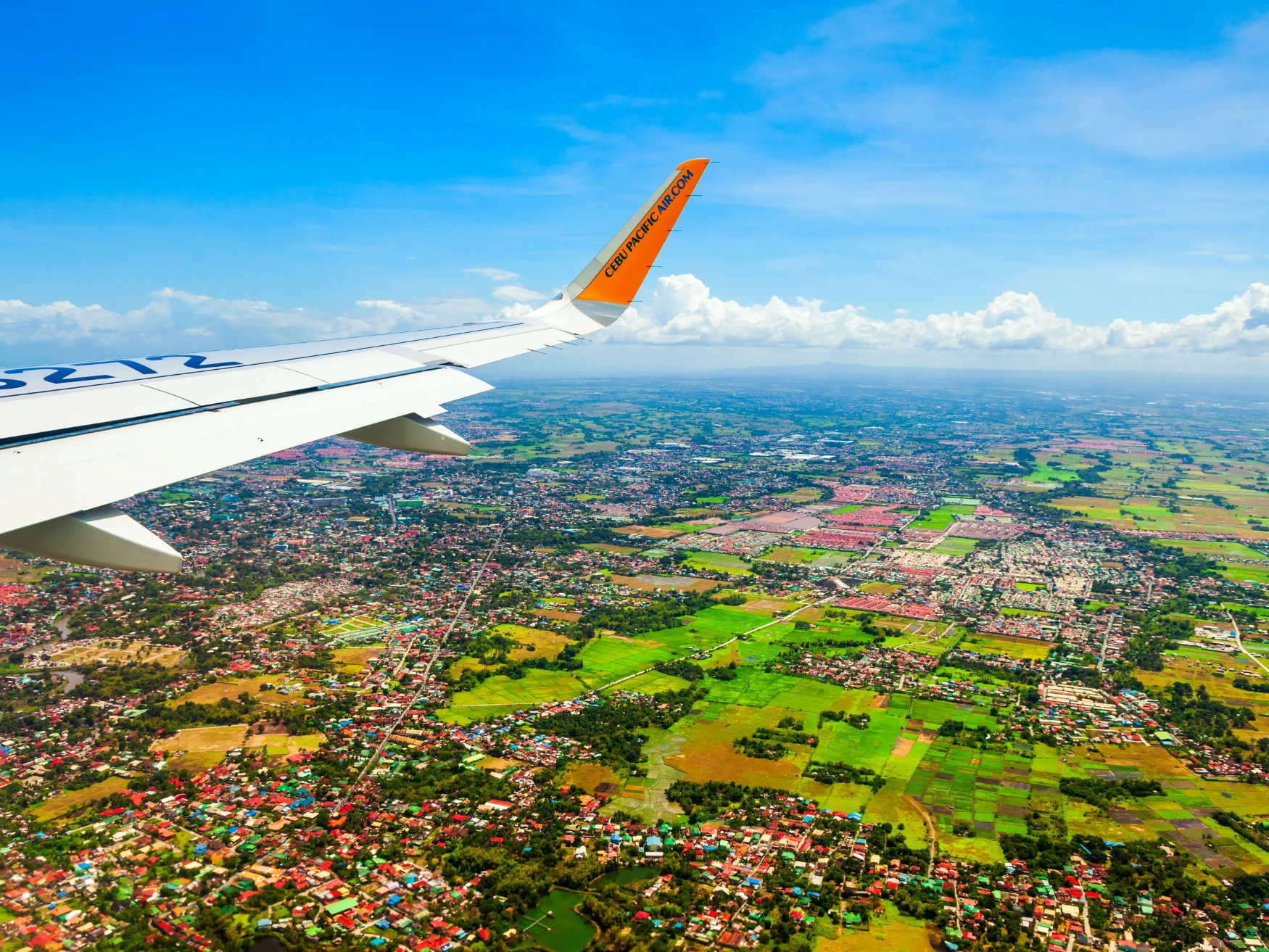 View of green land from an aircraft window, illustrating flight planning from Chennai to the Philippines