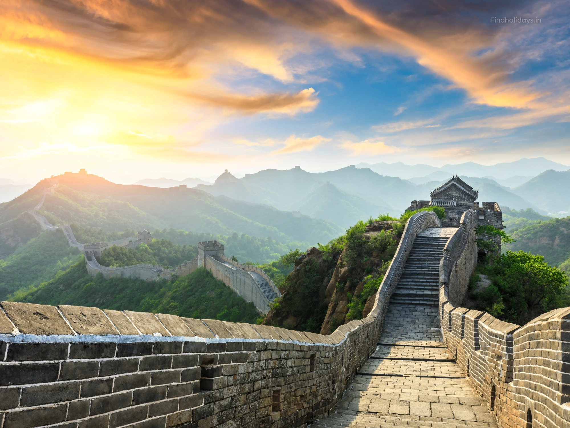Great Wall of China winding over mountains at sunset