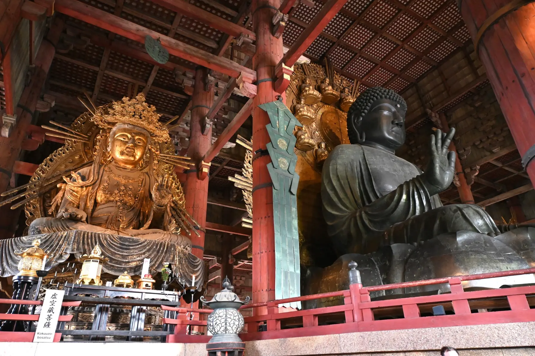 Sacred bowing sika deer in Nara Park in front of the monumental wooden Great Buddha Hall at Todai-ji Temple