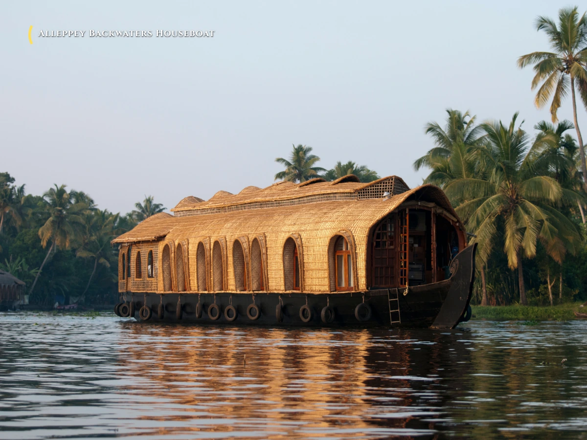Traditional Kettuvallam luxury houseboat cruising through the palm-fringed backwaters of Alleppey Alappuzha Kerala